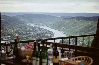 Weinprobe Mosel mit Blick über das Moseltal bei Bernkastel-Kues – Tisch mit Flaschen und Gläsern