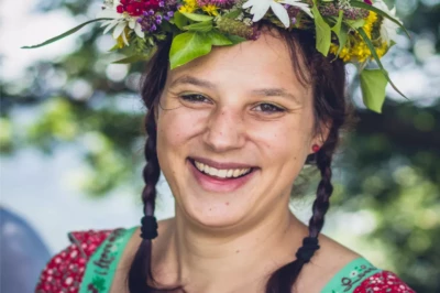 Weinprobe Mosel: fröhliche Teilnehmerin mit Blumenkranz beim Event, Porträt